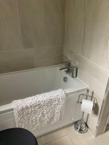 y baño con bañera y toalla. en Gwaelodygarth Lodge en Merthyr Tydfil