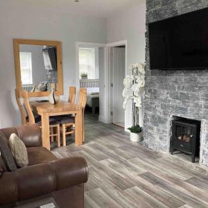 sala de estar con mesa y chimenea en Gwaelodygarth Lodge en Merthyr Tydfil