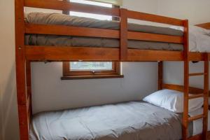 Tempat tidur susun dalam kamar di Parque Pinares House Pucón con acceso al lago
