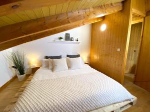 een groot wit bed in een kamer met houten wanden bij Ático Dúplex Con Increibles Vistas a La Valle De Incles - Parking Gratis in Incles
