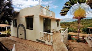 uma casa com uma escada e uma palmeira em FINCA VILLA MAGALY en medio de la Naturaleza em Melgar