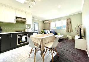 a kitchen and living room with a table and chairs at Albany Modern Private 2 bedroom 2 bathroom with Full Kitchen Netflix in Auckland
