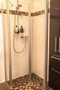 La salle de bains est pourvue d'une douche avec une porte en verre. dans l'établissement Modern, fully equipped apartment, ideal for Messe fair, à Hanovre