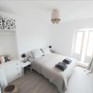 een witte slaapkamer met een bed en een kroonluchter bij Artists Apartment Montpellier-Place de la Comédie in Montpellier