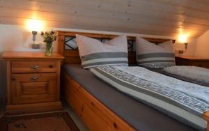 two twin beds in a room with wooden walls at Bauernhof Dieing in Isny im Allgäu