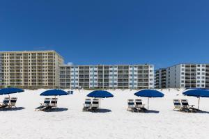 a group of chairs and blue umbrellas on the beach at Island Shores 654 in Gulf Shores