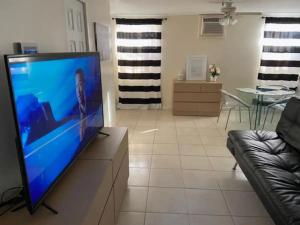 salon z telewizorem z płaskim ekranem na komodzie w obiekcie Cozy Private House near Miami Airport - Free parking - 02 w Miami