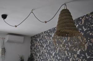 um lustre pendurado no tecto num quarto em Azahares Apartamento turístico em El Bosque