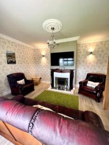 a living room with a couch and a fireplace at The Myles' Self-Catering Cottage - 4 Stars in Greencastle