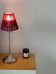 a lamp and a candle on a wooden table at Location courte durée, jolie appartement lumineux in Vantaa