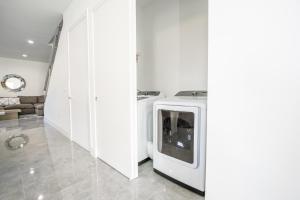 - un lave-linge et un sèche-linge blancs dans une pièce blanche dans l'établissement Modern 4-Bedroom Townhouse with Pool!, à Miami