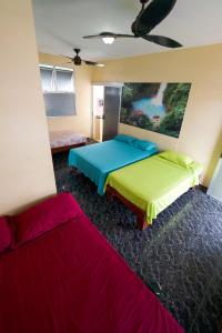 um quarto com duas camas e um quadro na parede em Hostel de Haan em Jacó