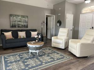 a living room with a couch and a table and chairs at Southern Charm meets sunny FL fun! Home with pool and central to everything. in Cape Coral