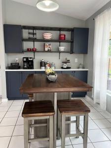 a kitchen with a wooden table and two stools at Southern Charm meets sunny FL fun! Home with pool and central to everything. in Cape Coral