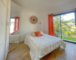 a bedroom with a bed and a large window at La Villa Bégonia in La Penne-sur-Huveaune