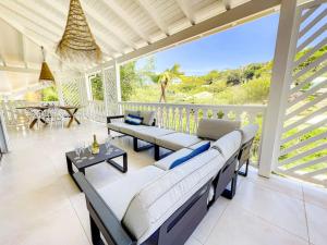 un patio con divani, tavoli e vista sull'oceano di Villa Bulle clothing optional around the prival pool a Orient Bay