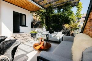an outdoor patio with couches and a table at The Edgewater Suites - Park View in Namur