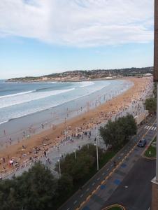 a view of a beach with crowds of people at Encanto del Cantábrico in Gijón