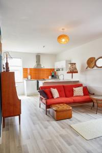 a living room with a red couch and a kitchen at Binks - Seafront 1 bed first floor apartment in Cleethorpes