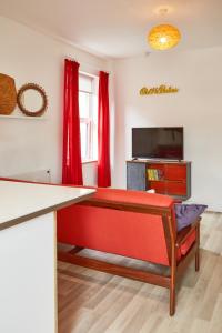 sala de estar con sofá rojo y TV en Binks - Seafront 1 bed first floor apartment, en Cleethorpes