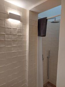 a bathroom with a shower with white tiles at Cosy Terrace House - design, comfort, micro-pool, top location in Olhão in Olhão