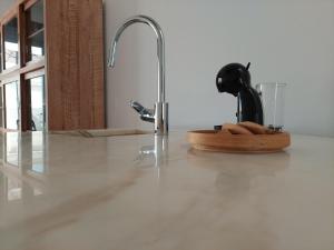 un bancone della cucina con lavandino e rubinetto di Cosy Terrace House - design, comfort, micro-pool, top location in Olhão a Olhão