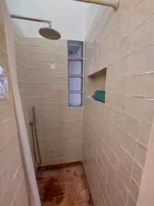 a bathroom with a shower with a tiled wall at Cosy Terrace House - design, comfort, micro-pool, top location in Olhão in Olhão