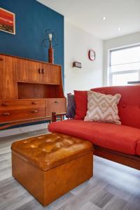 sala de estar con sofá rojo y piano en Binks - Seafront 1 bed first floor apartment, en Cleethorpes