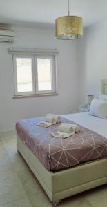 a bedroom with a bed with two towels on it at Casa Dourada in Alvor