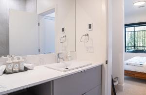 a white bathroom with a sink and a mirror at Slopes and Greens by Revelstoke Vacations in Revelstoke