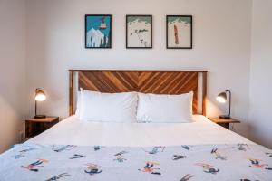 雷夫爾斯托克的住宿－Slopes and Greens by Revelstoke Vacations，卧室配有一张床,墙上有三幅照片