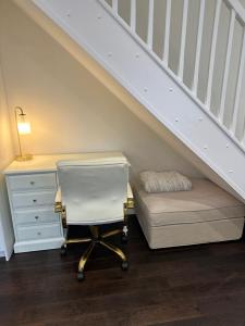 um quarto com uma cadeira e uma secretária debaixo de uma escada em 1 bedroom modern house near hospital with parking em Southampton