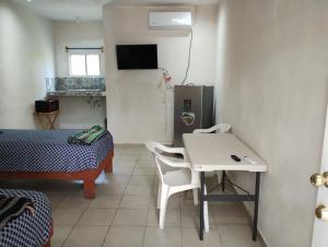 Habitación pequeña con mesa blanca y nevera. en Apts. LOSSANTOS en Matamoros