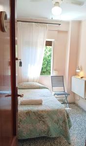a bedroom with a bed and a chair and a window at Habitaciones en Apartamento compartido DELICIAS ROOM Cerca del Mar, Aeropuerto, Ave y Metro in Málaga