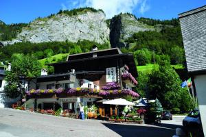a building with flowers on it in front of a mountain at Alpenhotel La Montanara in Rocca Pietore