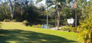 a park with a body of water and trees at Three Rivers Cabin in Yandina