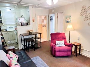 a living room with a red chair and a table at #06 - Lakeview Two Bedroom Cottage-Pet Friendly in Hot Springs