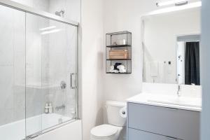 a bathroom with a shower and a toilet and a sink at The Monashee House by Revelstoke Vacations in Revelstoke