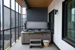 a grill sitting on a porch with a stool at The Monashee House by Revelstoke Vacations in Revelstoke