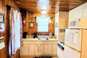 cocina con nevera blanca y fregadero en #08 - One Bedroom Lakeview Cottage-Pet Friendly en Hot Springs