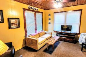 uma sala de estar com um sofá e uma televisão em #08 - One Bedroom Lakeview Cottage-Pet Friendly em Hot Springs
