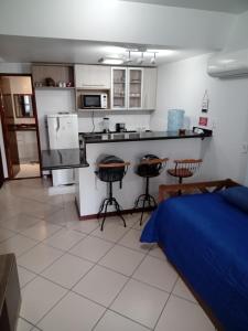 a bedroom with a bed and a kitchen with a counter at Loft na Prainha - Arraial do Cabo in Arraial do Cabo