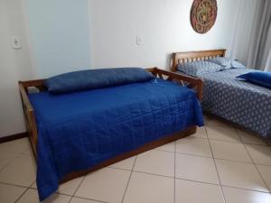 two beds with blue sheets in a room at Loft na Prainha - Arraial do Cabo in Arraial do Cabo +10 photos