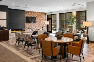 a lobby with tables and chairs and a fireplace at Courtyard by Marriott Bozeman in Bozeman