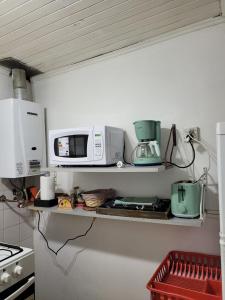 a kitchen shelf with a microwave and other appliances on it at Kren in Ushuaia +7 photos