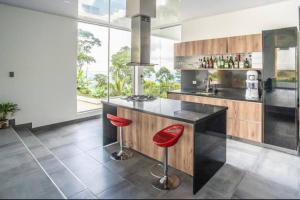 a kitchen with a counter with red stools at Espectacular Quinta privada in Viotá