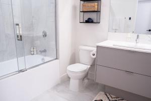 a bathroom with a toilet and a shower and a sink at The Selkirk House by Revelstoke Vacations in Revelstoke