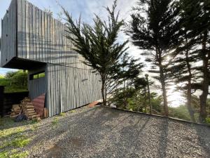 una vista exterior de una casa con una entrada de grava en Almar de Matanzas Tiny, en Boca Pupuya