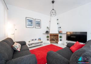 ein Wohnzimmer mit einem Sofa und einem roten Teppich in der Unterkunft Casa Juan Sebastian Elcano in Gelves