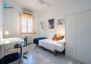 Schlafzimmer mit einem Bett, einem Schreibtisch und einem Tisch in der Unterkunft Casa Juan Sebastian Elcano in Gelves